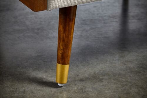 Close-up of wooden chair leg with gold accent for modern furniture.