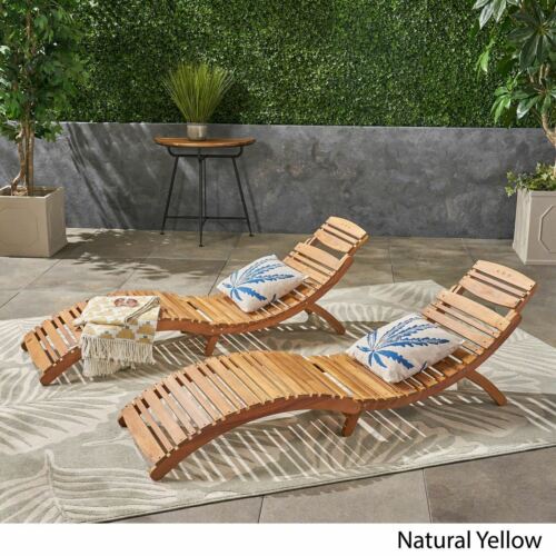 Two natural yellow wooden lounge chairs with pillows on a patio.